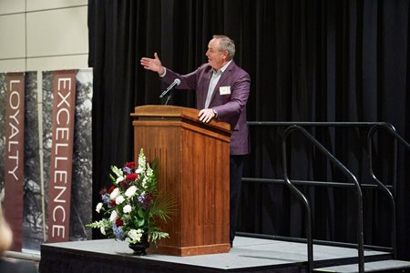 Speaker speaking at a podium at military social event